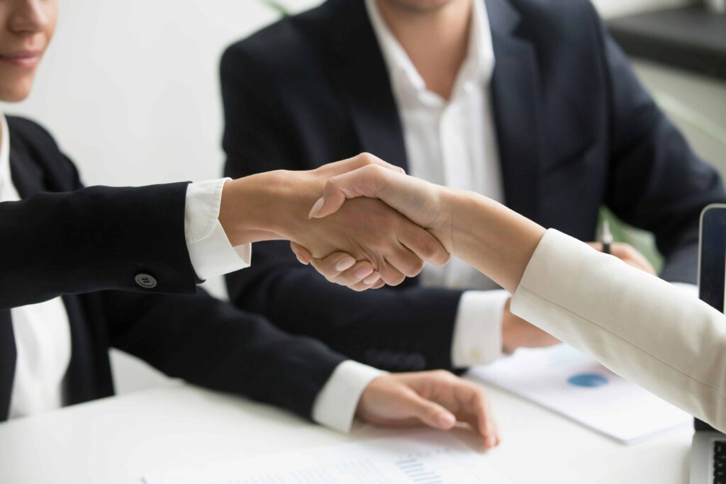 Hands shaking in a professional setting, symbolizing partnership and legal representation, relevant to tax resolution services offered by Margolies Law Office in Dallas.